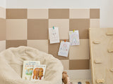 Children's playroom with checkered wall, bean bag, toys, and a basket.