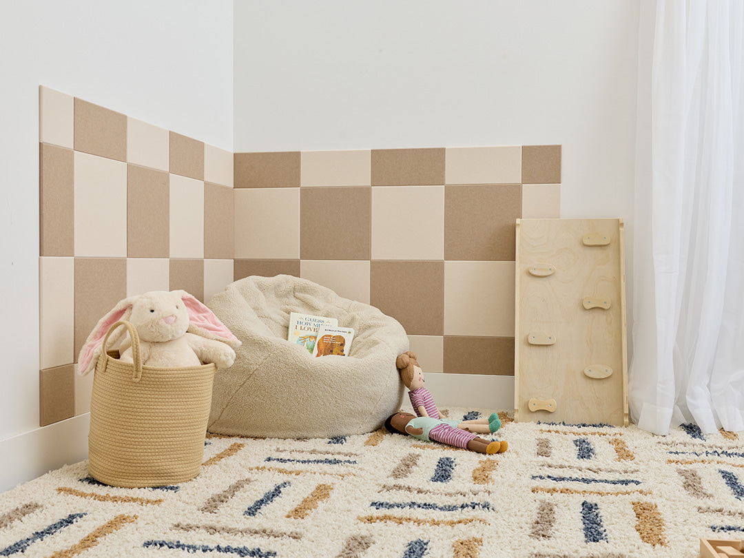 Children's playroom with checkered wall, bean bag, toys, and a basket.