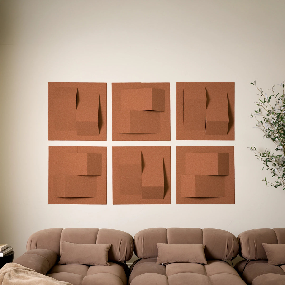 Dark orange acoustic felt tiles with peak design above a couch 