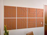 Eight cinnamon and periwinkle subway tile panels with geometric line patterns mounted on a white wall.