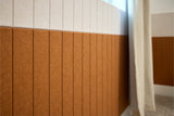 Wall paneling with rust-brown vertical grooved lower section and light beige upper section divided by horizontal seam.