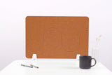 Tan desk divider with wavy cutout design, two white support feet, displayed on white desk with mug and vase.
