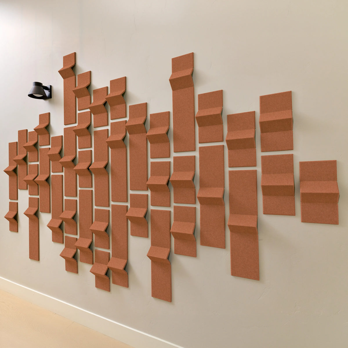 Dark orange acoustic tiles with peak points on a wall