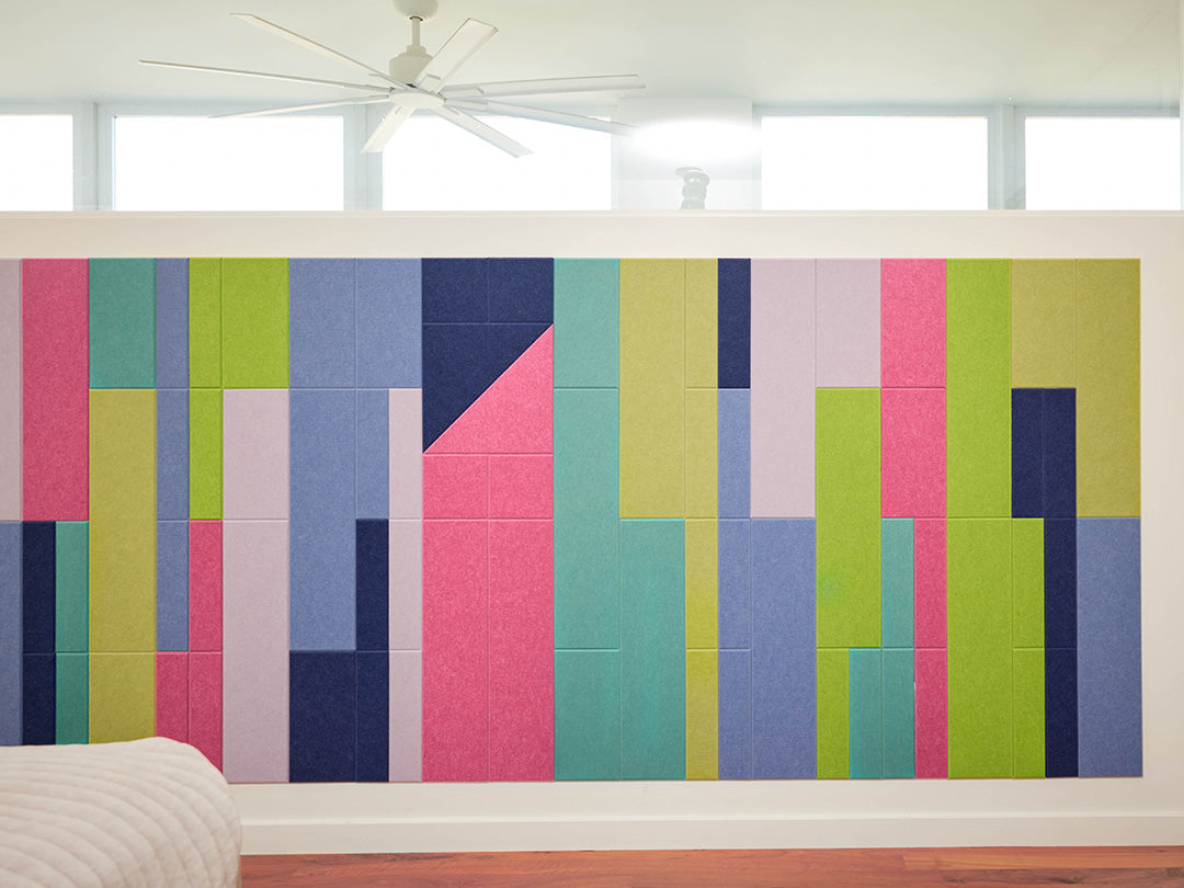Colorful geometric wall paneling in a room with large windows.