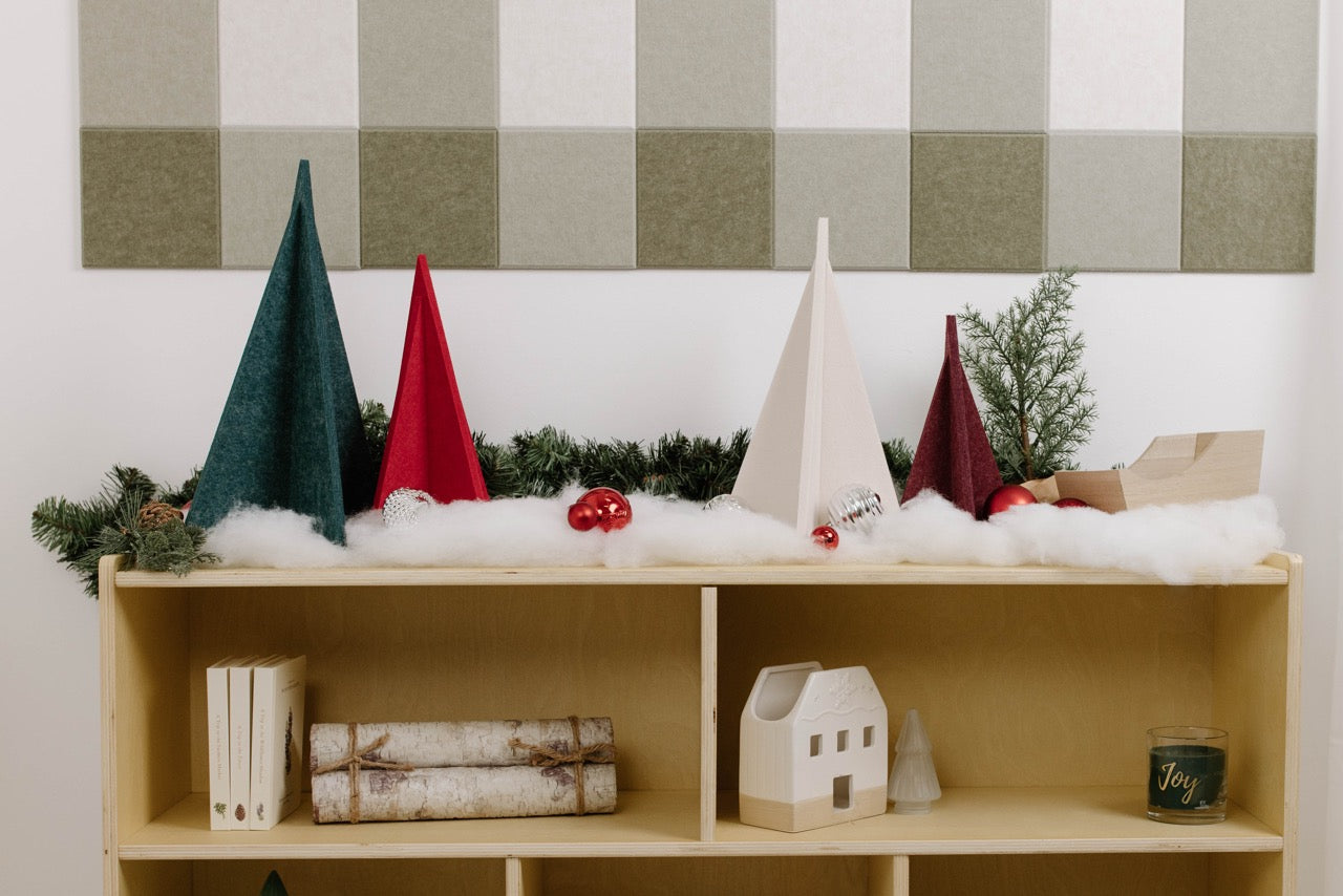 Wooden shelf with Christmas decorations against a plaid wall.
