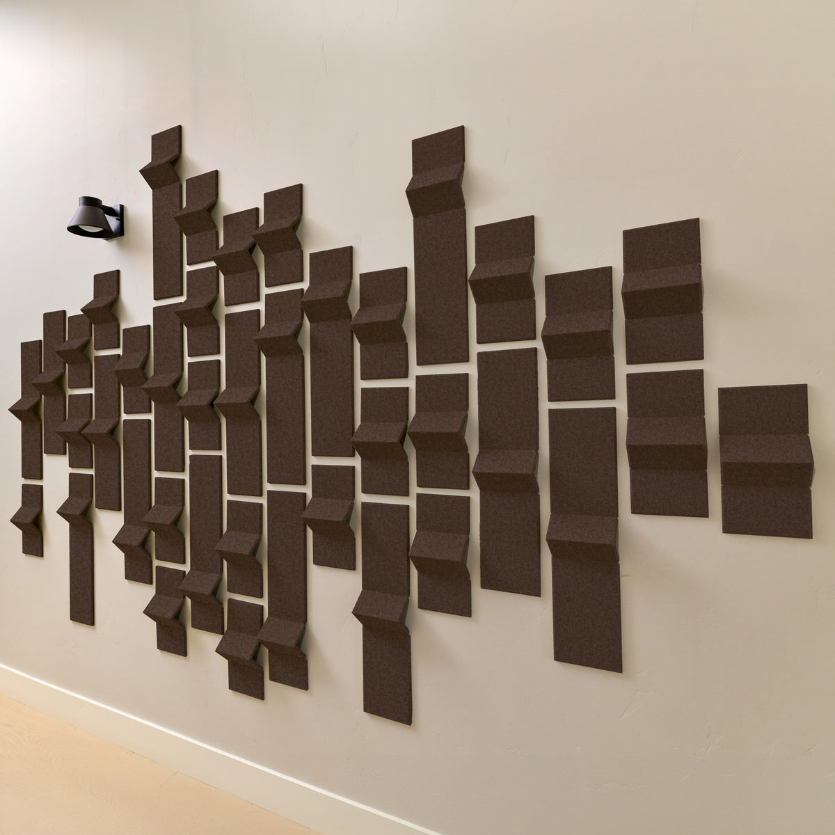 Dark brown acoustic felt tiles on a wall with points 
