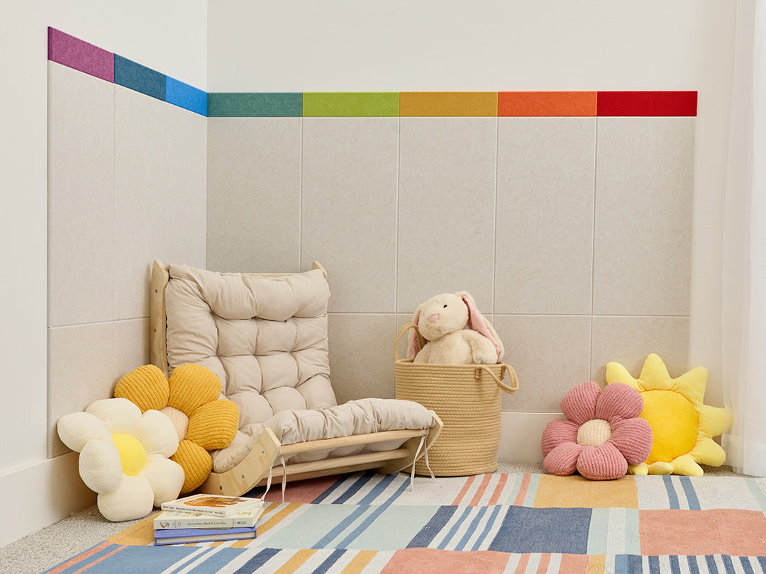 Children's playroom with a colorful rug, toys, and a wall with a rainbow stripe.