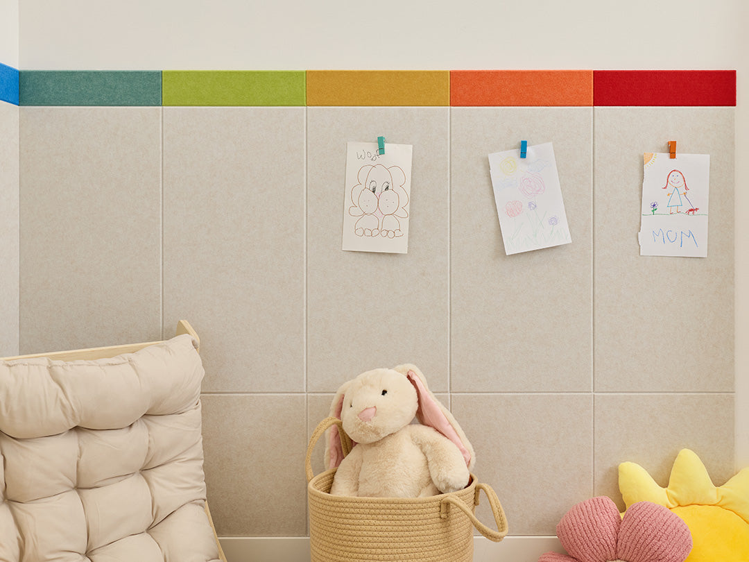 Children's playroom with a colorful rug, toys, and a wall with a rainbow stripe.