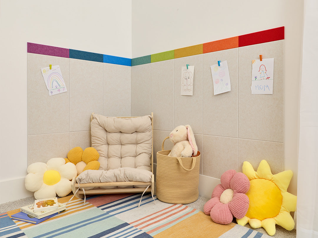 Children's playroom with a colorful rug, toys, and a wall with a rainbow stripe.