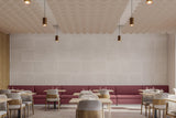 Engraved felt panels on a wall of a restaurant with scalloped ceiling blades hanging from the ceiling