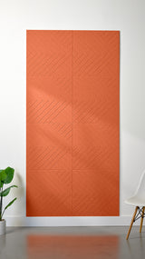 Orange Felt Right 4’ x 8’ PET felt panel with geometric lines engraved into the material against a white wall. A plant and chair are in the foreground.