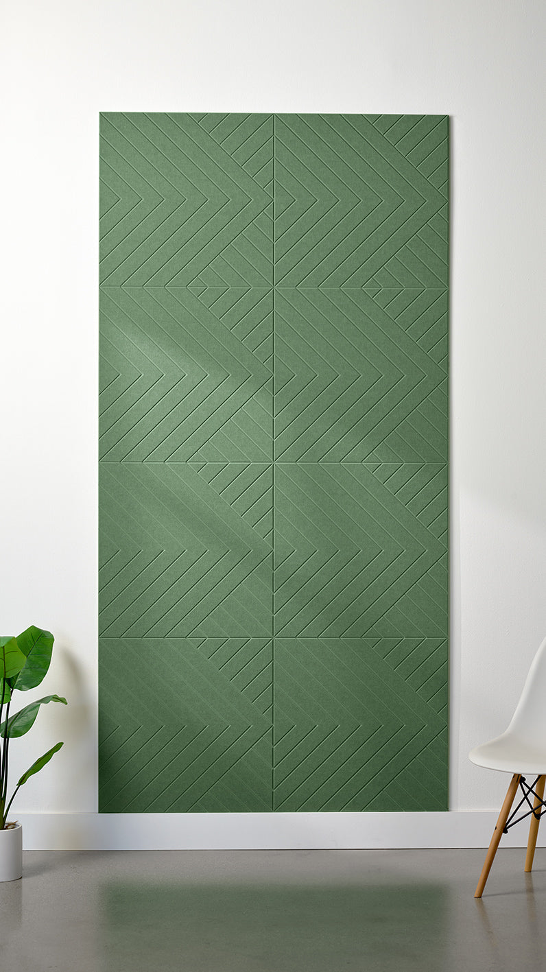 Green Felt Right 4’ x 8’ PET felt panel with geometric lines engraved into the material against a white wall. A plant and chair are in the foreground.