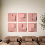 Light pink acoustic felt tiles with a 3D design along a wall in a room with a couch
