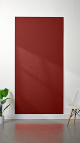 Burgundy felt sheet with geometric chevron engraved pattern displayed on white wall.