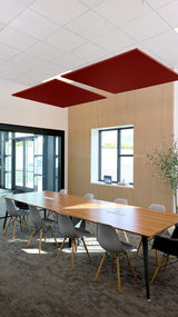 Two burgundy square flat acoustic baffles suspended from ceiling grid above conference table.
