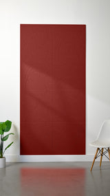 Red felt sheet with engraved topographic contour line pattern, displayed on white wall.
