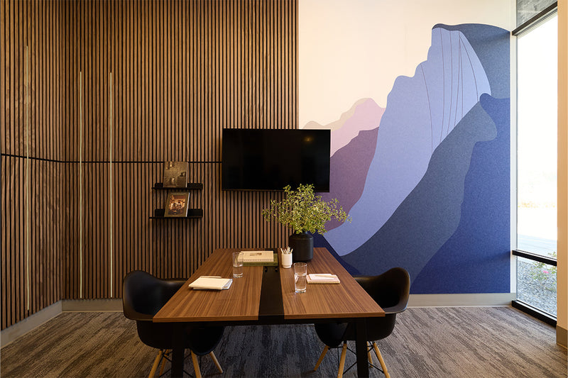 Meeting room with wood slat paneling and custom Yosemite mural made out of purple and white felt