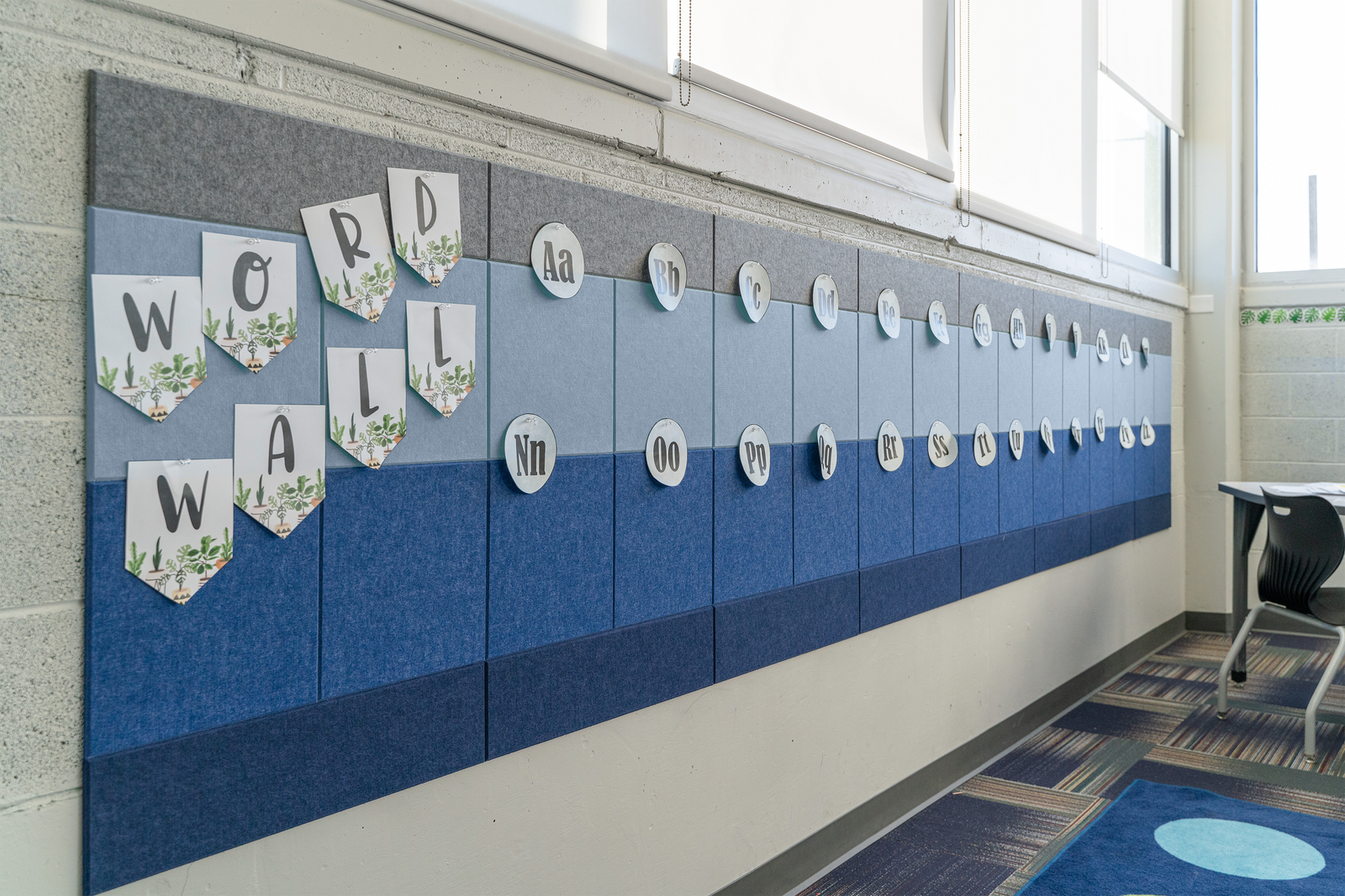 A felt right wall art design on a wall in a classroom that is pinable and different shades of blue and grey.