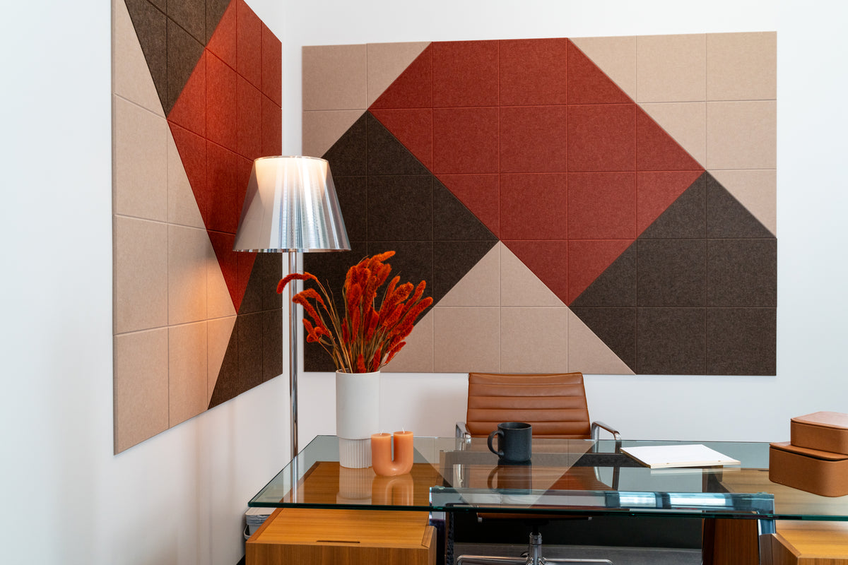 Felt Right wall art design in shades of brown, cream, and red patterned on two walls in an office by a desk and a lamp in the corner.