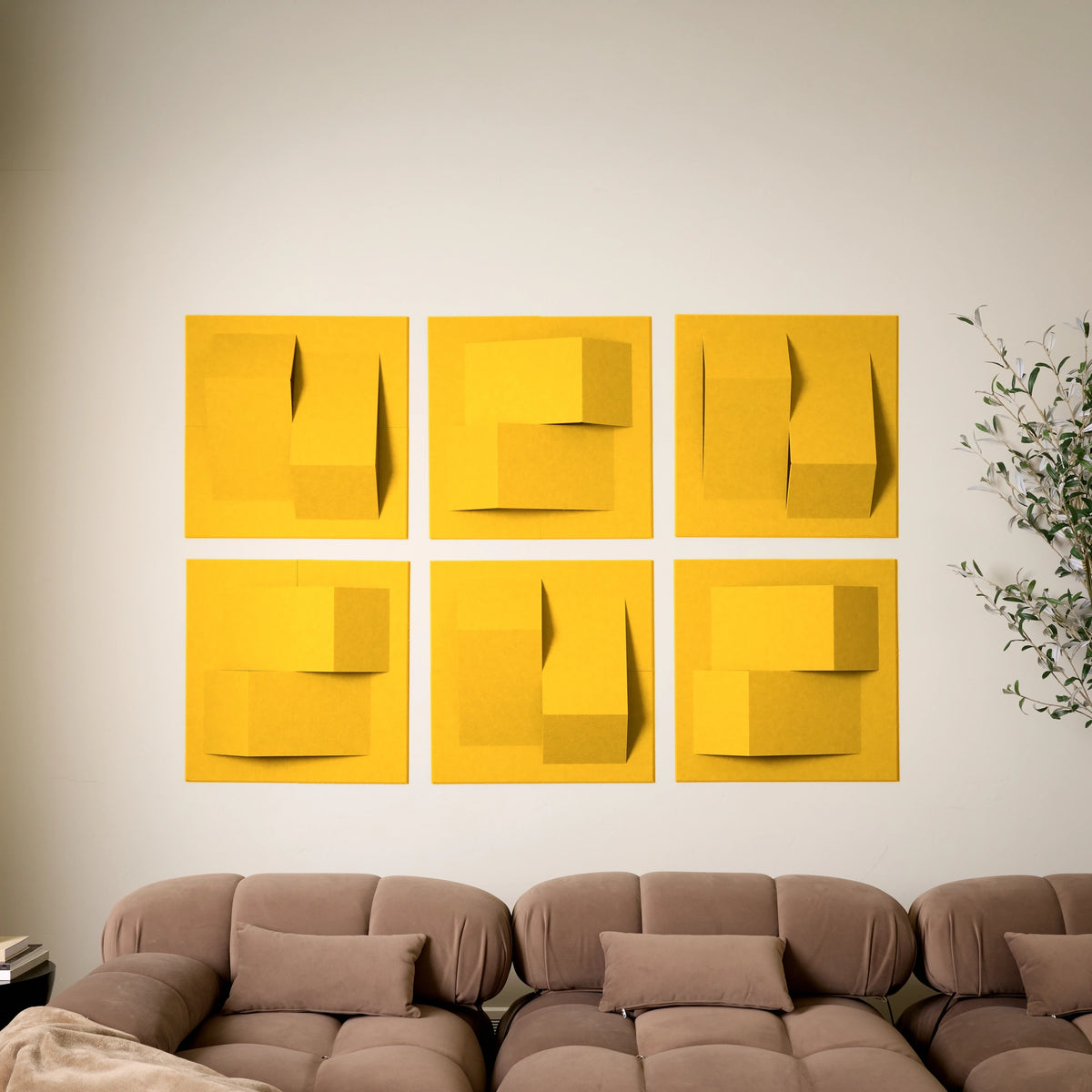 Yellow felt acoustic tiles on a wall above a couch in a room