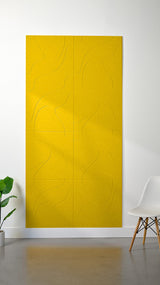 Yellow felt sheet with engraved topographic contour lines and grid pattern, mounted on white wall.