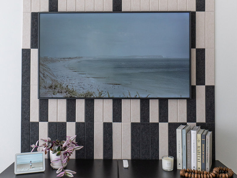 Felt Right wall art design using black and cream felt tiles in a shiplap look on a wall with a tv mounted on the tiles and tv stand below with home decor on it
