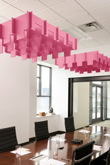 Pink 3D cloud-shaped acoustic baffle panels suspended from ceiling above conference table.