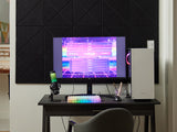 Felt Right tiles with a cross pattern in the color black on a white wall behind a desk with a gaming computer