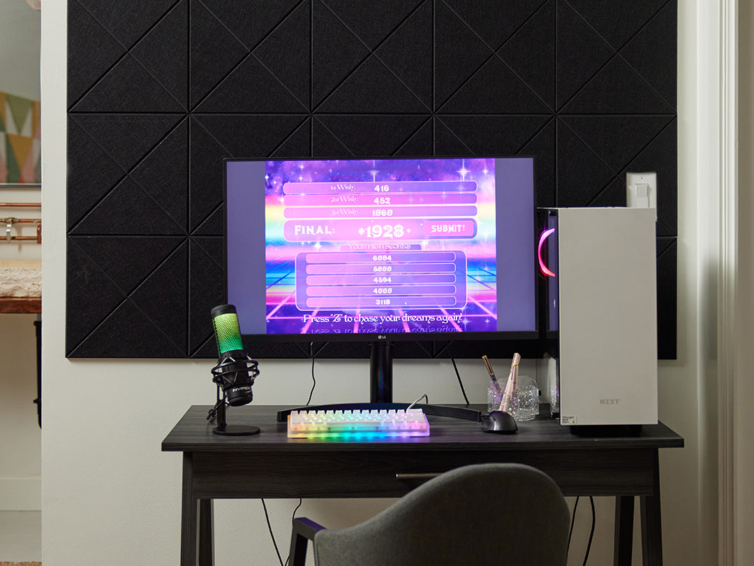 Felt Right tiles with a cross pattern in the color black on a white wall behind a desk with a gaming computer