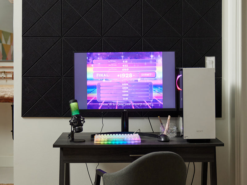 Felt Right tiles with a cross pattern in the color black on a white wall behind a desk with a gaming computer