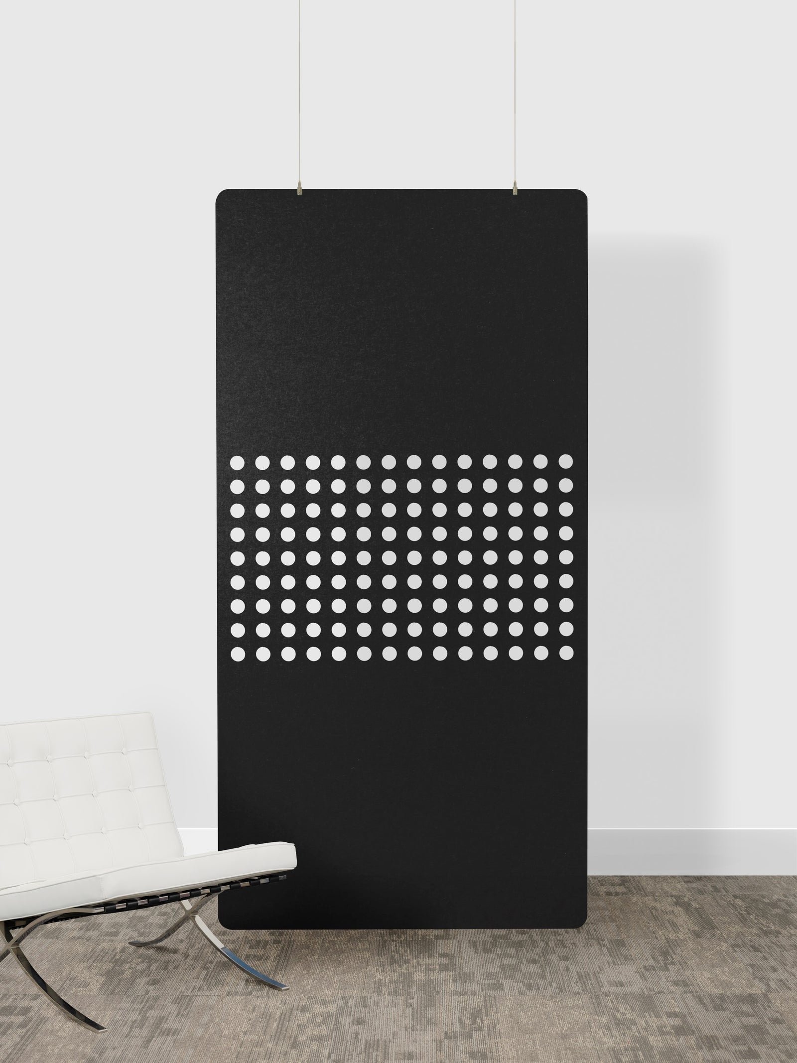 Black panel with white dot pattern on a white wall