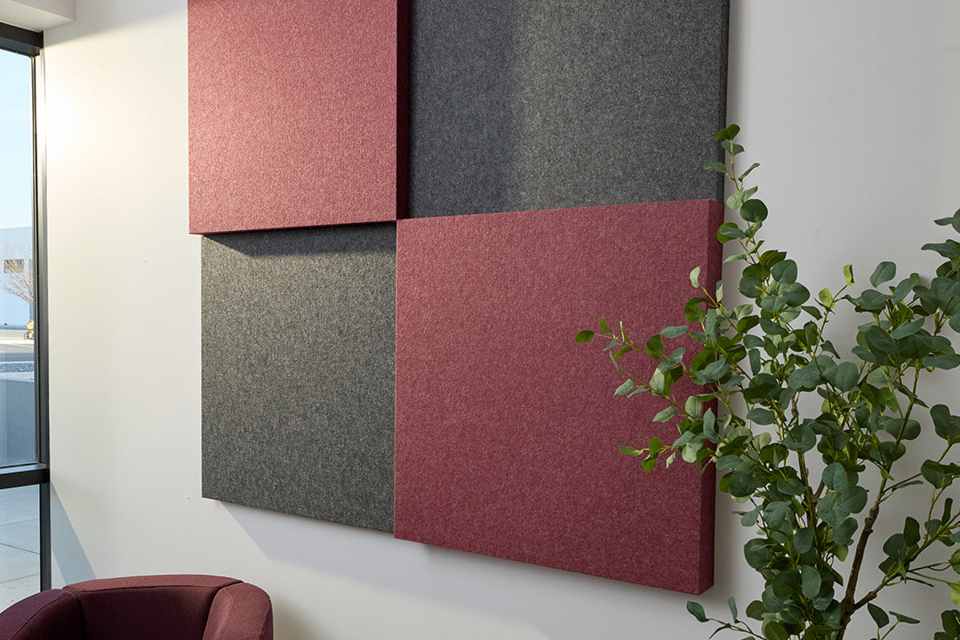 Red and grey acoustic panels on wall next to tree