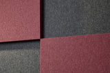 Four square acoustic tiles with maroon and gray textured patterns.