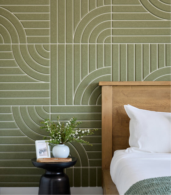 Bedroom with green geometric wall tiles and wooden headboard