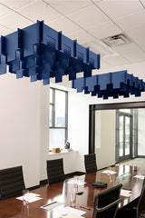 Navy blue modular acoustic baffles suspended from ceiling in office conference room above wooden table.