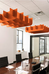 Two orange 3D cloud-shaped acoustic baffles suspended from ceiling above conference table.