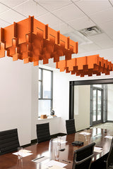 Orange 3D modular cloud baffles suspended from ceiling in office conference room.