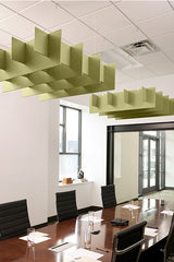 Green acoustic baffles with 3D grid pattern suspended from ceiling above conference table.