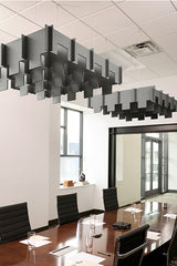 Gray 3D modular ceiling baffles suspended above a conference table in an office space.