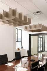 Tan curved ceiling baffles suspended above a conference table in an office meeting room.