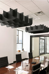 Black curved acoustic baffles suspended from drop ceiling above conference table in modern office space.