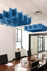 Blue 3D cloud-shaped acoustic baffles suspended from ceiling above conference table.