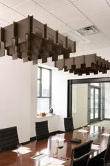 Brown 3D cloud baffles suspended from drop ceiling above conference table in office space.