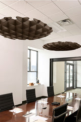 Two dark brown 3D cloud-shaped acoustic baffles suspended from a drop ceiling above a conference table.