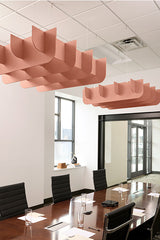 Coral-pink 3D cloud-shaped acoustic baffles suspended from ceiling above conference table.