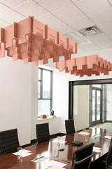 Terracotta 3D modular cloud-shaped acoustic baffle suspended above conference table in office space.