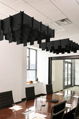 Black 3D modular cloud baffles suspended from ceiling in office conference room.