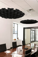 Black 3D cloud-shaped acoustic baffles suspended from drop ceiling in office conference room.