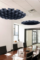 Two navy blue 3D cloud-shaped acoustic baffles suspended from ceiling above conference table.