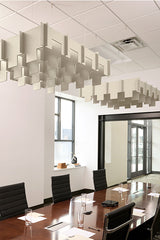 Drop 3D Cloud Baffle acoustic panels suspended from ceiling in staggered geometric pattern above conference table.